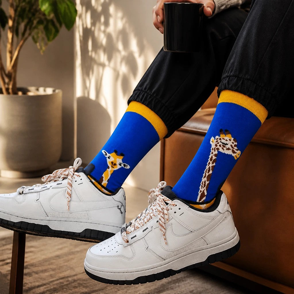 Qorapa LaraLara royal blue crew socks with giraffe pattern and yellow cuffs worn with white sneakers