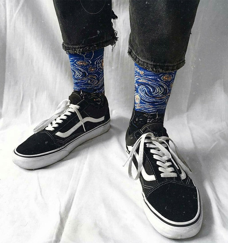 Qorapa LaraLara crew socks featuring a blue Starry Night impressionist print worn with black sneakers and jeans.