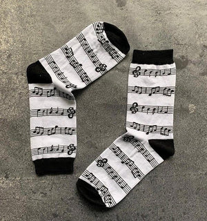 Qorapa LaraLara crew socks featuring a black and white musical note and staff pattern with reinforced black heels.