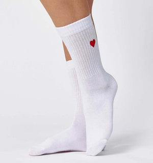 Qorapa LaraLara white cotton crew socks featuring a small embroidered red heart on the ribbed cuff worn on feet