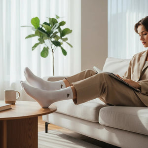 Qorapa LaraLara white cotton crew socks with embroidered pizza detail worn by a woman relaxing on a sofa