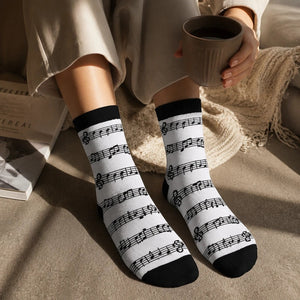 Qorapa LaraLara crew socks featuring a black musical note and staff pattern on white fabric with black toe and heel.