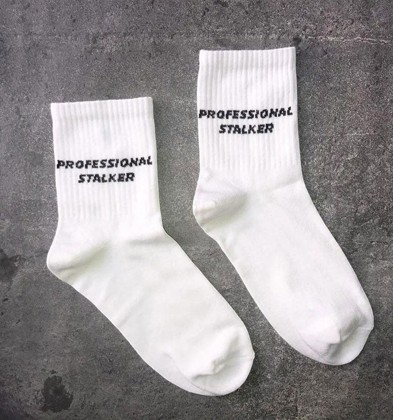 Qorapa LaraLara white crew socks with black Professional Stalker text embroidery in a soft cotton-blend fabric.